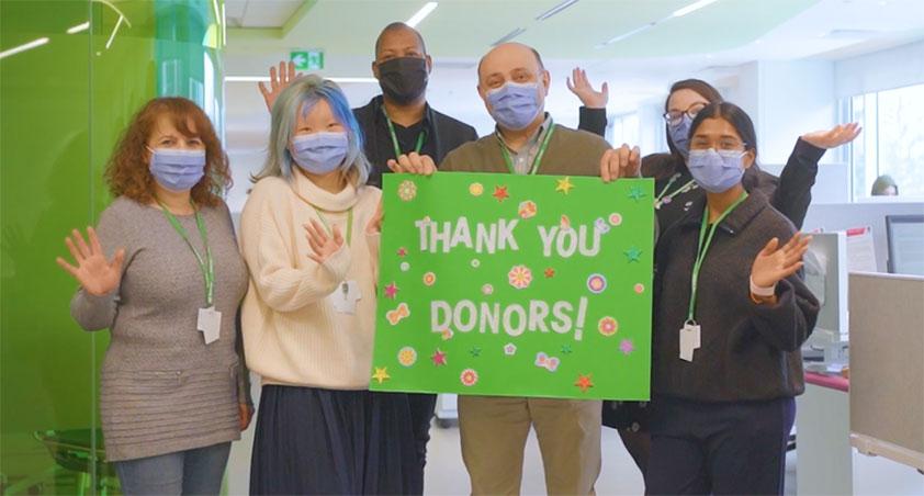 Holland Bloorview staffs holding a thank you card to thank donors